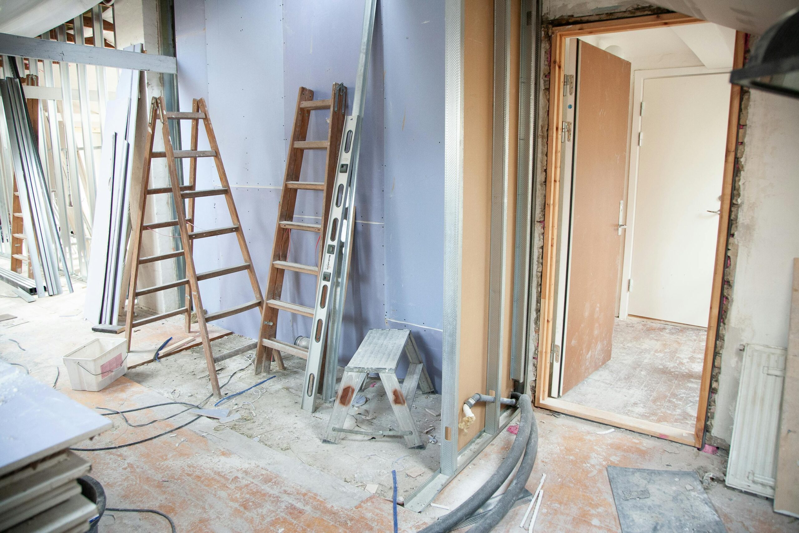 Home renovation in progress with exposed walls, construction tools, and building materials.