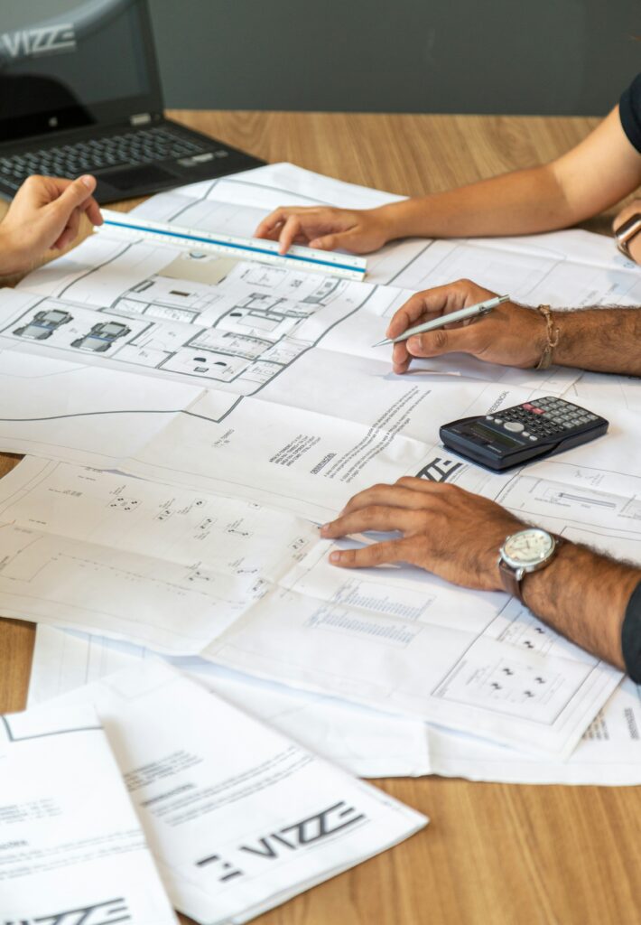 Close-up of renovation plans on a table with blueprints, measuring tape, and sample materials.